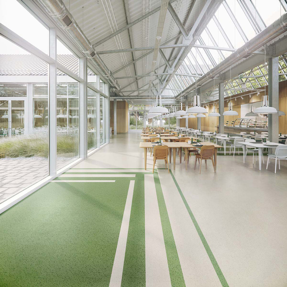 Green and light-gray smooth-profile ColorSpec rubber flooring tiles installed in a modern interior with large windows and seating